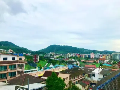 a city with buildings and mountains in the background at The Luka Guesthouse in Patong Beach