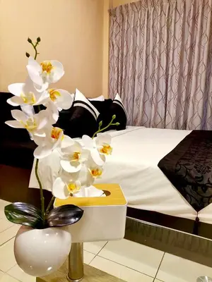 a bedroom with a bed and a table with white flowers at The Luka Guesthouse in Patong Beach