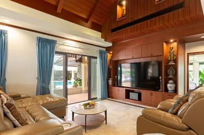 a living room with leather couches and a flat screen tv at Villa Carlos, Luxury 7 BDR Private Pool Villa, Baan Bua Nai Harn, Phuket in Rawai Beach