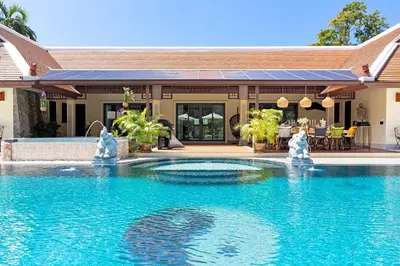 a swimming pool with water fountains in front of a house at Villa Carlos, Luxury 7 BDR Private Pool Villa, Baan Bua Nai Harn, Phuket in Rawai Beach