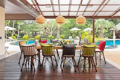 a patio with a table and chairs and a pool at Villa Carlos, Luxury 7 BDR Private Pool Villa, Baan Bua Nai Harn, Phuket in Rawai Beach