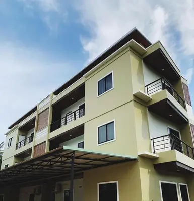 a yellow building with balconies on top of it at Himma's Apartment in Kamala Beach