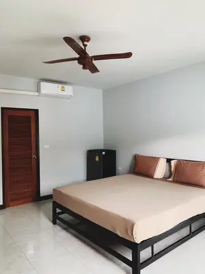 a bedroom with a bed with a ceiling fan at Himma's Apartment in Kamala Beach
