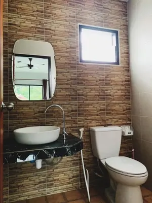 a bathroom with a toilet and a sink and a mirror at Himma's Apartment in Kamala Beach