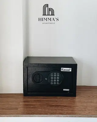 a black microwave sitting on top of a wooden floor at Himma's Apartment in Kamala Beach