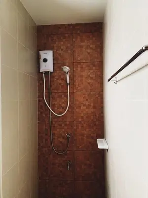 a shower in a bathroom with a brick wall at Himma's Apartment in Kamala Beach