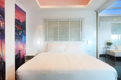 a bedroom with a large white bed with a window at PATONG TOWER EXCLUSIVE FAMILYs SEA VIEW 2025 in Patong Beach