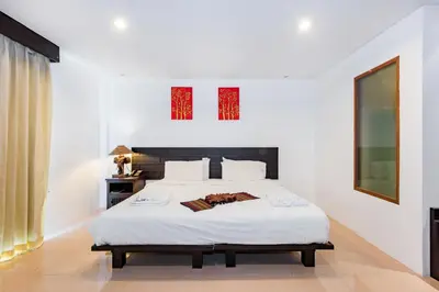 a bedroom with a large bed with white sheets at My Hotel Phuket in Patong Beach