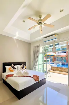 a bedroom with a bed and a ceiling fan at Sea Boss Homestay in Kata Beach