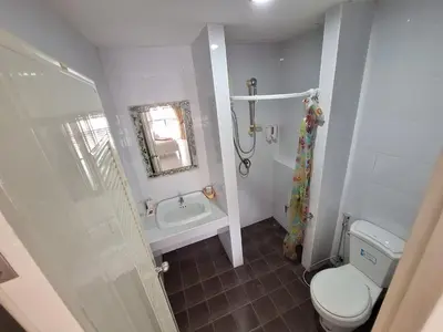 a white bathroom with a toilet and a sink at Sea Boss Homestay in Kata Beach