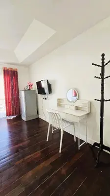 a room with a white desk and a television at Sea Boss Homestay in Kata Beach