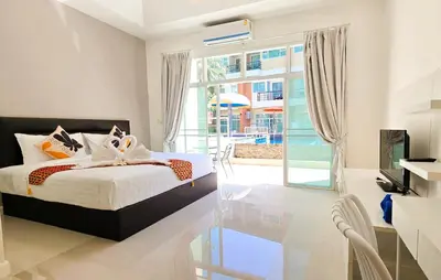 a bedroom with a bed and a large window at Sea Boss Homestay in Kata Beach