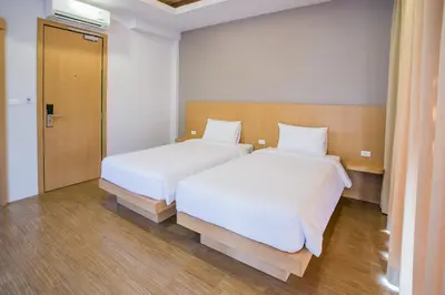 two beds in a small room with a door at Casa De Coral Boutique Hotel in Kata Beach