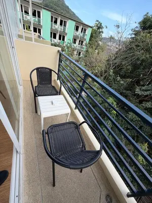two chairs and a table on a balcony at Casa De Coral Boutique Hotel in Kata Beach