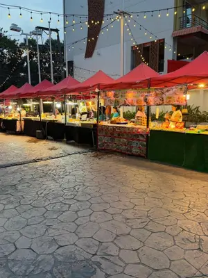 a fruit stand with red umbrellas on a city street at Casa De Coral Boutique Hotel in Kata Beach