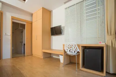 a room with a desk with a tv and a chair at Casa De Coral Boutique Hotel in Kata Beach