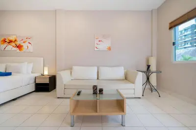 a living room with a couch and a coffee table at Jungceylon Villa - quiet location, pool, maid in Patong Beach