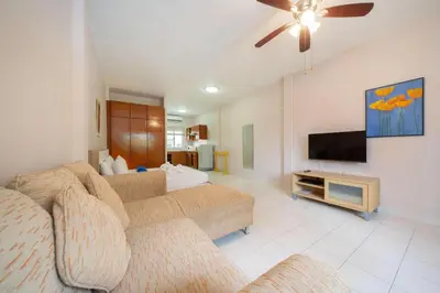 a living room with a couch and a flat screen tv at Jungceylon Villa - quiet location, pool, maid in Patong Beach