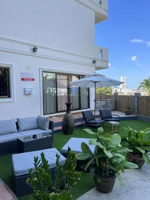 a patio with a couch and chairs and an umbrella at Riviera Patong in Patong Beach