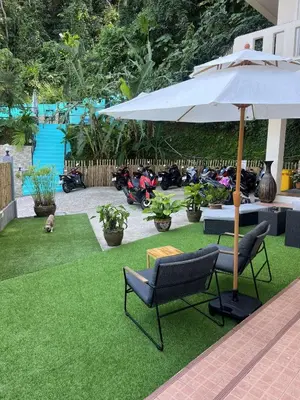 a patio with a table and an umbrella and chairs at Riviera Patong in Patong Beach