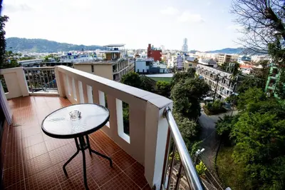 a table on a balcony with a view of a city at Riviera Patong in Patong Beach