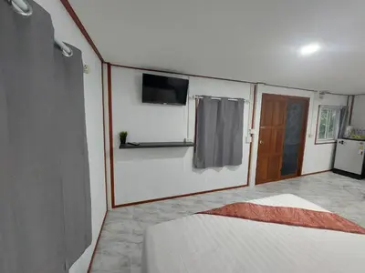 a bedroom with a bed and a tv on the wall at Phuketnumnoi23 in Surin Beach
