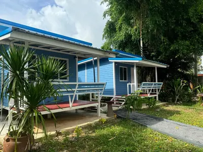 a blue house with two benches in front of it at Phuketnumnoi23 in Surin Beach