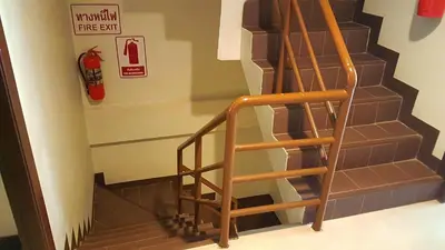 a wooden staircase with a fire extinguisher on the wall at Southern Comfort Patong in Patong Beach