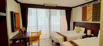 a hotel room with two beds and a window at Southern Comfort Patong in Patong Beach