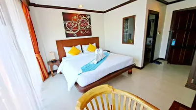 a bedroom with a bed and a chair in it at Southern Comfort Patong in Patong Beach