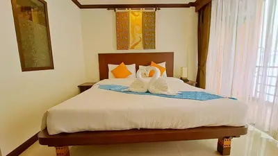 a bedroom with a bed with two shoes on it at Southern Comfort Patong in Patong Beach