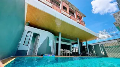 a building with a swimming pool in front of a building at Ratana Hotel Sakdidet, PHUKET TOWN in Phuket Town