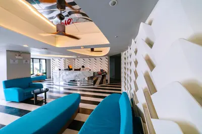 a lobby with blue chairs and a bar at Ratana Hotel Sakdidet, PHUKET TOWN in Phuket Town