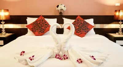 two swansuitsrendered to look like they are sitting on a bed at Ratana Residence Thalang in Thalang