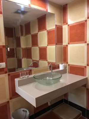a bathroom with a sink with a large mirror at Relaxation guesthouse in Thalang