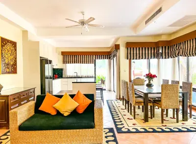 a living room with a green couch and a table at 3-4BR Laguna Phuket Golf Course Villa with Pool & Jacuzzi in Laguna Phuket