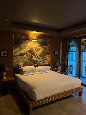 a bedroom with a large bed with a painting on the wall at Grand Orlov Apart Hotel in Patong Beach