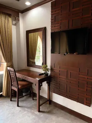 a room with a desk with a mirror and a television at Grand Orlov Apart Hotel in Patong Beach