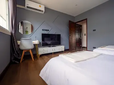 a bedroom with a bed and a tv and a chair at Grand Orlov Apart Hotel in Patong Beach