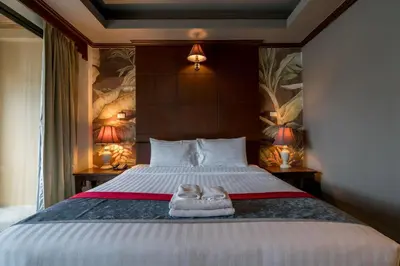 a bedroom with a bed with a pair of shoes on it at Grand Orlov Apart Hotel in Patong Beach