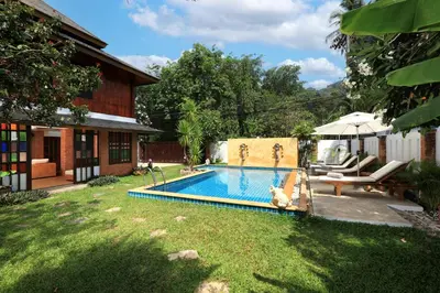 a swimming pool in a yard next to a house at WoLin Lemon Resort in Ban Saiyuan (1)