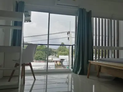 a room with a large window with a chair and a bed at Baan7984 Rawai in Rawai Beach
