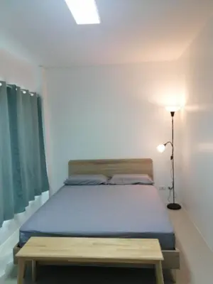 a bedroom with a bed with a blue mattress and a lamp at Baan7984 Rawai in Rawai Beach