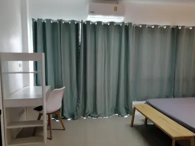 a bedroom with green curtains and a desk and a bed at Baan7984 Rawai in Rawai Beach