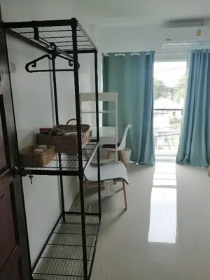 a room with a shelf with baskets and a chair at Baan7984 Rawai in Rawai Beach