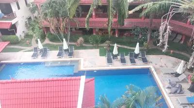 an overhead view of a swimming pool with chairs and umbrellas at Appartamento Patong Beach, all'interno del Sai Rougn residence in Patong Beach