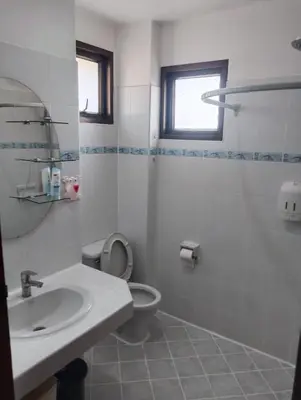 a white bathroom with a sink and a toilet at Appartamento Patong Beach, all'interno del Sai Rougn residence in Patong Beach