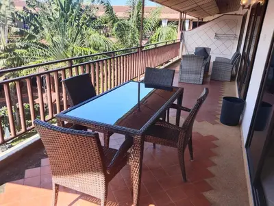 a patio with a table and chairs on a balcony at Appartamento Patong Beach, all'interno del Sai Rougn residence in Patong Beach