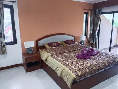 a bedroom with a large bed with purple decorations on it at Appartamento Patong Beach, all'interno del Sai Rougn residence in Patong Beach
