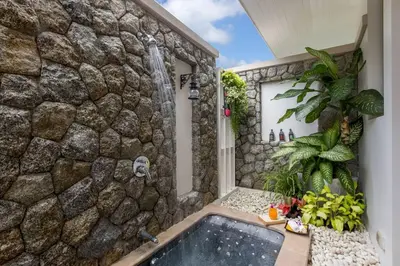 a bathroom with a stone wall and a bath tub at Katamanda 3 Bed Tropical Villa B3 Near Kata Beach in Kata Beach